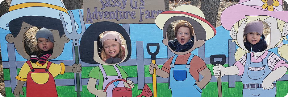 Children posing in farm-themed cutout board.